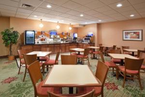 a restaurant with tables and chairs and a counter at Holiday Inn Express Hotel & Suites Cleveland-Streetsboro by IHG in Streetsboro