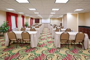 a conference room with tables and chairs and a screen at Holiday Inn Express Hotel & Suites Cleveland-Streetsboro, an IHG Hotel in Streetsboro