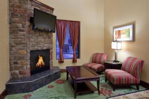 a living room with a fireplace and a tv at Holiday Inn Express Hotel & Suites Cleveland-Streetsboro by IHG in Streetsboro