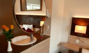 a bathroom with a sink and a mirror at Business Class Hotel Ebersberg in Ebersberg