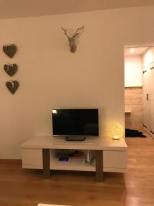 uma sala de estar com uma mesa com televisão e corações na parede em Appartement Familie Willems Winterberg 3 em Winterberg