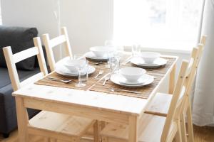 a wooden table with plates and glasses on it at Vienna Living Apartments - Hasnerstraße in Vienna