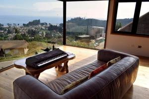 uma sala de estar com um sofá e um computador portátil sobre uma mesa em Samadhi Lodge Pingueral em Dichato