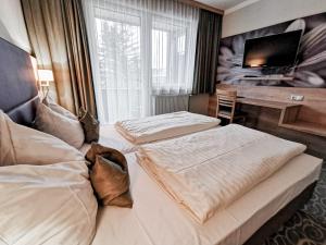リエンツにあるGasthof Schlossberghofのベッド2台とデスクが備わるホテルルームです。
