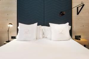a bedroom with a large bed with white pillows at One Shot Tabakalera House in Donostia-San Sebastián