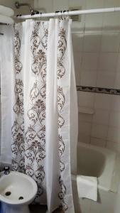 a bathroom with a white shower curtain and a sink at Luminoso Depto con terraza propia y en la mejor ubicación in Córdoba
