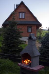 une maison en briques avec une cheminée en face de celle-ci dans l'établissement NATURA PARK BIESZCZADY - DOMKI CAŁOROCZNE, à Baligród