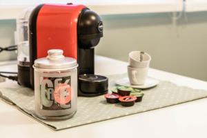 a coffee maker and some cupcakes on a counter at Welcome to Milan and More! in Varedo