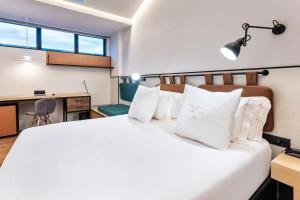 a bedroom with a large bed with white pillows at One Shot Tabakalera House in Donostia-San Sebastián