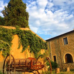 un banco de madera sentado frente a un edificio en Agriturismo San Carlo, en Pomarance