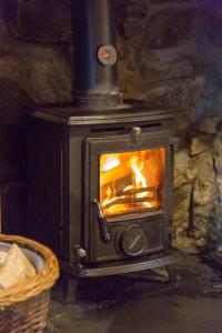 a black stove with a fire in it at Mountview Cottage in Lochinver