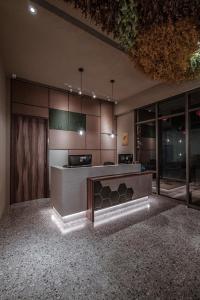 台南市にあるSomer Chew Hotelのカウンター付きのキッチン、ガラスのドアが備わります。