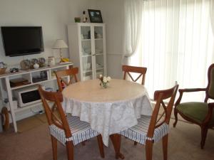 Benington的住宿－Cobblestones，客厅配有桌椅和电视