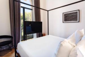 a hotel room with a bed and a tv at One Shot Tabakalera House in Donostia-San Sebastián