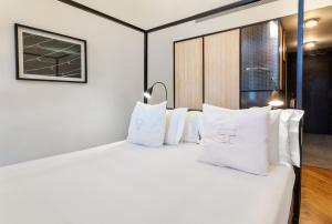 a bedroom with a white bed with white pillows at One Shot Tabakalera House in Donostia-San Sebastián