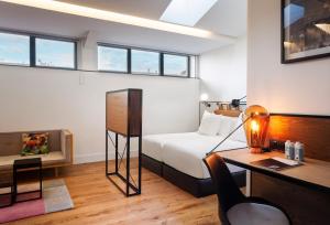 a bedroom with a bed and a desk and a desk at One Shot Tabakalera House in Donostia-San Sebastián