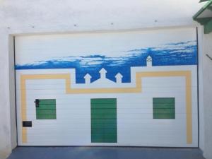 een witte garagedeur met een schilderij erop bij Casa Tinasoria in La Asomada