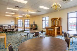 a room with tables and chairs and a piano at Econo Lodge Waupaca in Waupaca