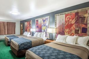 a hotel room with two beds and paintings on the wall at Econo Lodge Waupaca in Waupaca +11 photos