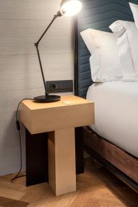 a desk with a lamp on it next to a bed at One Shot Tabakalera House in Donostia-San Sebastián