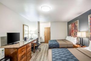 a hotel room with a bed and a desk with a computer at Econo Lodge Waupaca in Waupaca