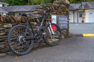 un vélo garé à côté d'un mur en pierre dans l'établissement Estuary Lodge Motel B&B, à Talsarnau