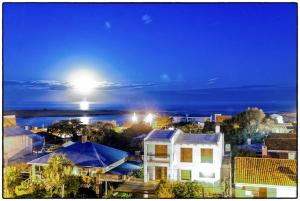 a view of a city at night with the moon at Hostel La Cruz del Sur in La Paloma