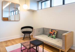a living room with a couch and a mirror at One Shot Tabakalera House in Donostia-San Sebastián