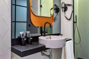 a bathroom with a sink and a mirror at One Shot Tabakalera House in Donostia-San Sebastián