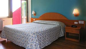 a bedroom with a bed with a blue wall at Hotel Cavalieri in Passignano sul Trasimeno