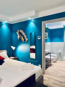 a blue bedroom with a bed and a bath tub at Dimora del Teatro in Treviso