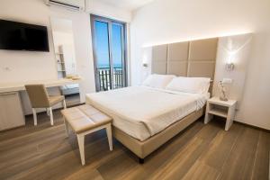 ベッラーリア・イジェア・マリーナにあるHotel Villa Sole Resortのベッドルーム1室(ベッド1台、デスク、テーブル付)