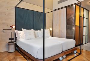 a bedroom with a large white bed with glass walls at One Shot Tabakalera House in Donostia-San Sebastián