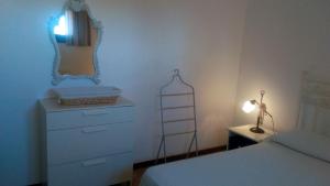 1 dormitorio con cama, tocador y espejo en Casa Gaia con vista Mare en Olbia
