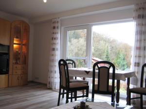a dining room with a table and chairs and a large window at Schloßberg Ferienwohnung in Waldeck +23 photos