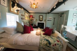 Wavehorne的住宿－The Woolpack Inn，一间卧室配有一张带红色枕头的大床