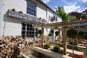 un restaurant avec un panneau sur le côté d'un bâtiment dans l'établissement The Woolpack Inn, à Wavehorne