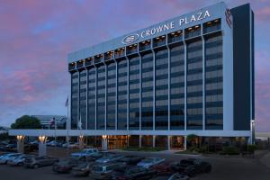a building with cars parked in a parking lot at Crowne Plaza San Antonio Airport, an IHG Hotel in San Antonio
