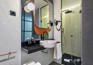 a bathroom with a sink and a mirror at One Shot Tabakalera House in Donostia-San Sebastián