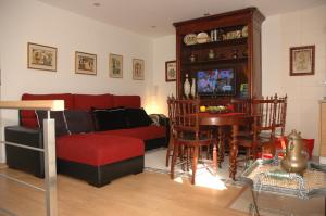 a living room with a red couch and a table at Casa Do Povo in Seia