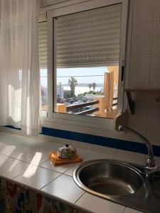 encimera de cocina con fregadero y ventana en Son de Mar 2, en Bolonia