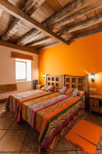 1 dormitorio con 1 cama grande y pared de color naranja en Arkaitza, en Berrobi
