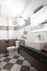 a bathroom with a sink and a toilet and a tub at Titanic 2 Hotel in Hanoi