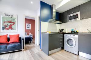 a kitchen with a washing machine and a couch at Nicebarcelonaapartments in Barcelona