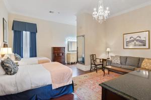 a hotel room with two beds and a couch at Andrew Jackson Hotel French Quarter in New Orleans
