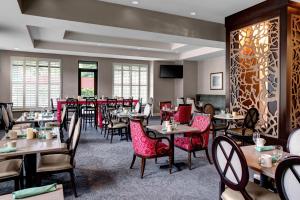 a restaurant with tables and chairs in a room at Holiday Inn Savannah Historic District by IHG in Savannah