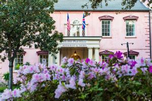 Un bâtiment rose avec un bouquet de fleurs devant lui dans l'établissement Holiday Inn Savannah Historic District, an IHG Hotel, à Savannah