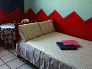 a bedroom with a bed with a red wall at Hotel Spada in Belém