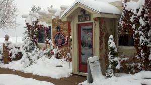 a store with a red door in the snow at Hilltop Inn Broomfield Denver in Broomfield
