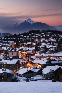 una ciudad cubierta de nieve con una montaña en el fondo en EA115 - 2 Pièces 6 Pers proche centre des Carroz, en Les Carroz d'Araches